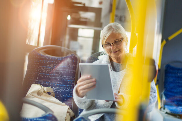 Older lady on bus using a tablet device